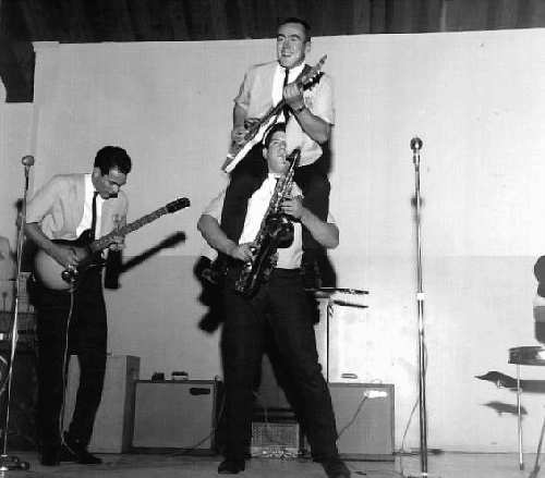 Norsemen - Don Nathman to the left playing the guitar, then Jim Coleman playing guitar whilst riding on Mike Scheil's shoulders; North Marion High School gymnasium. - Photo Courtesy of David Higginbotham